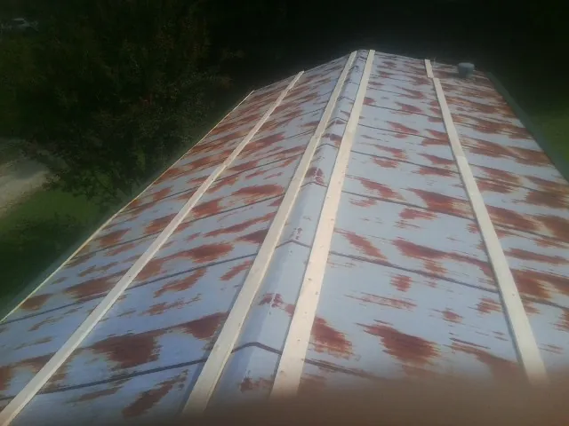 Rusted metal roof panels with new wood purlins before replacement — Storm Damage Roof Repair in Rensselaer by Roofing Brothers