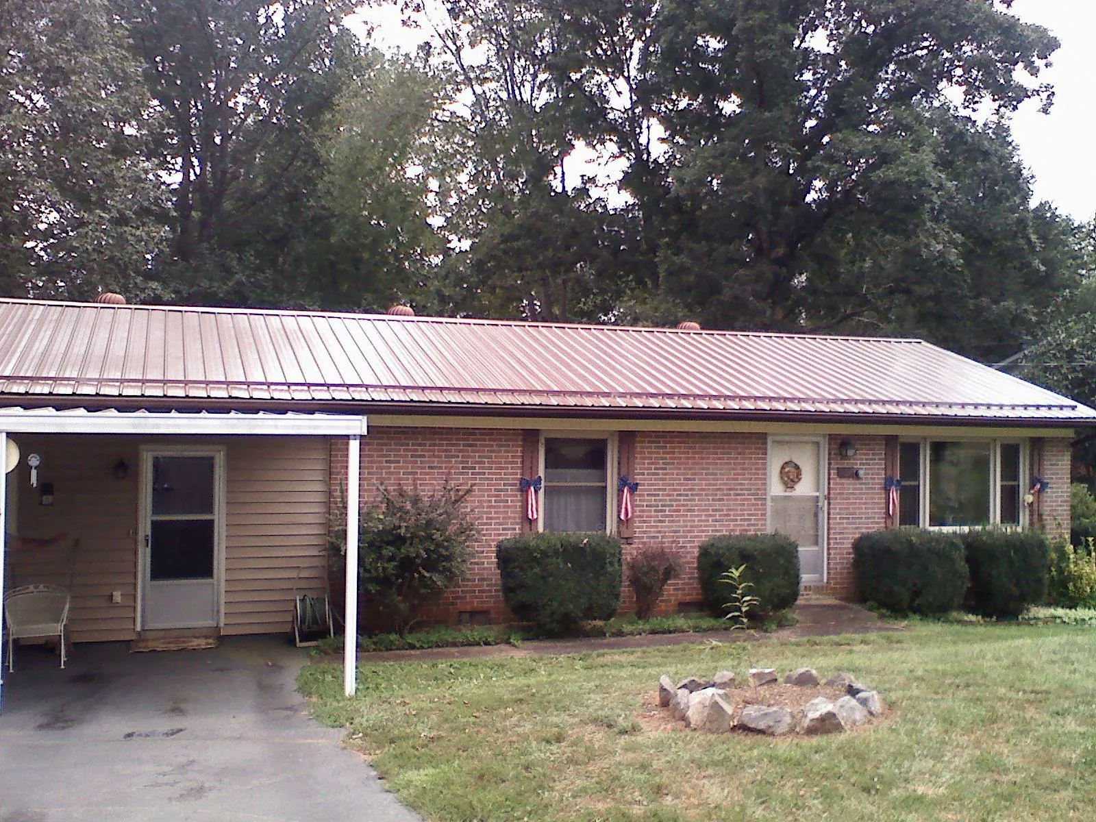 Bronze metal roof and carport on a brick ranch home — Roof Repair work by our crew in Rensselaer
